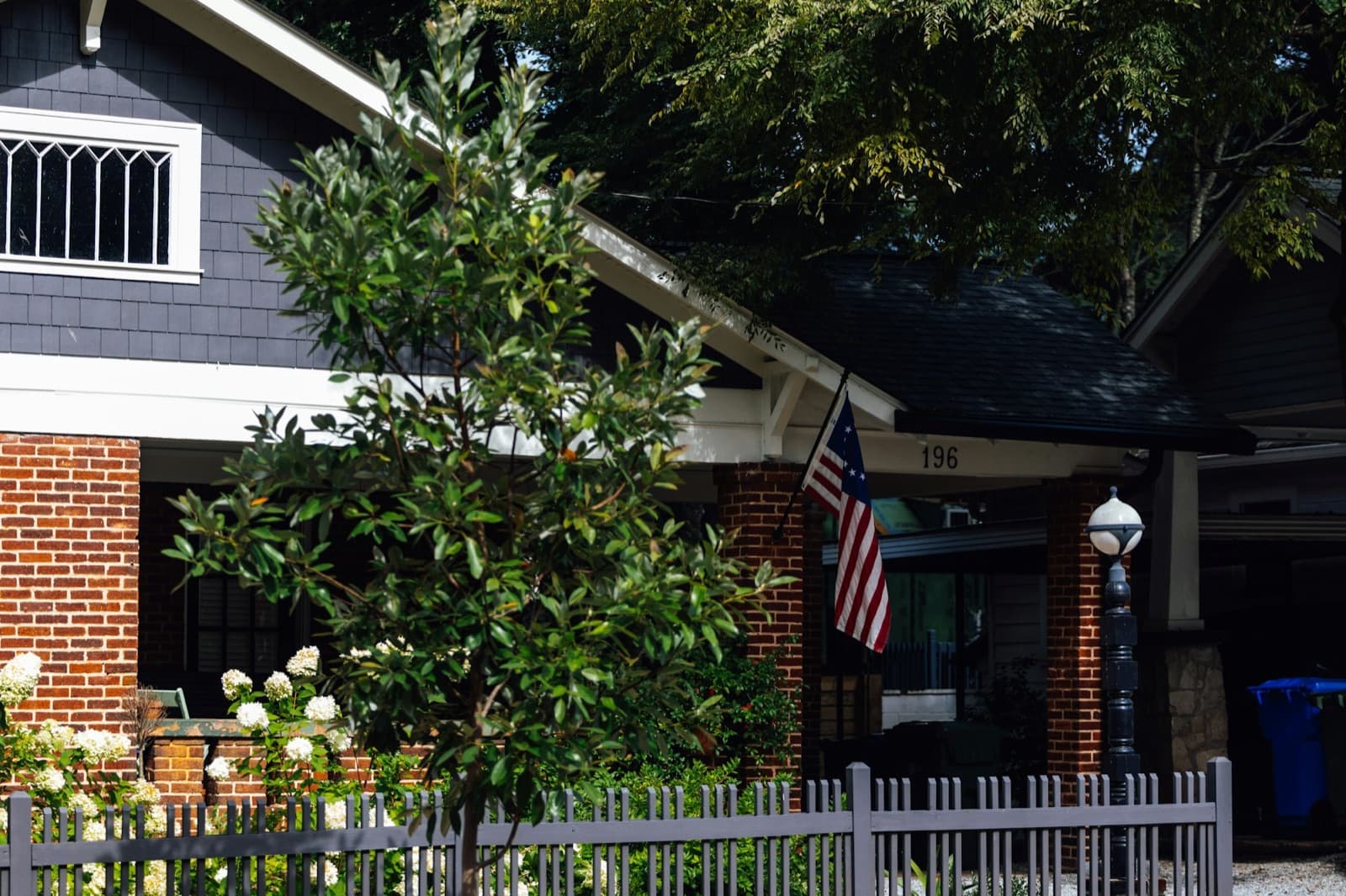 Brick house with a flag and a magnolia tree